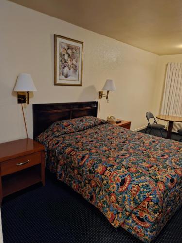 a hotel room with a bed with a colorful bedspread at Terrace Inn and Suites in El Cerrito