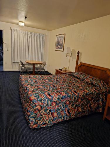 a hotel room with a bed and a table at Terrace Inn and Suites in El Cerrito