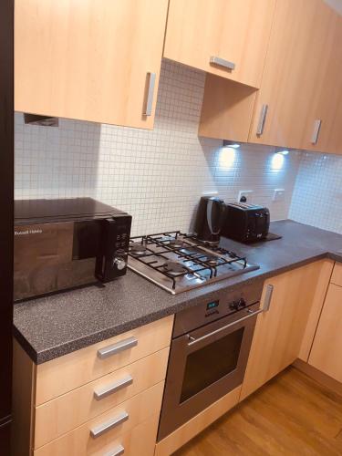 a kitchen with a stove and a microwave at Landed SA in Cardonald