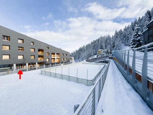 um edifício na neve com um campo de ténis em Monolocale sulle piste da sci em Pila