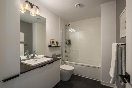 a white bathroom with a sink and a toilet at La totale : luxury 3 BR at the mountain in Mont-Tremblant