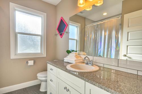 a bathroom with a sink and a toilet and a mirror at Alberta Arts District Home with Private Hot Tub! in Portland