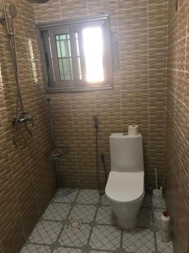 a small bathroom with a toilet and a window at Two bedroom apartment Paradise estate Apt in Bureng