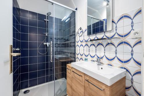 La salle de bains est pourvue d'un lavabo et d'une douche. dans l'établissement LE GLOBE TROTTEUR, à Saint-Laurent-du-Var