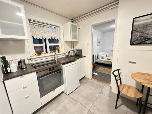 eine Küche mit weißen Schränken und einem Holztisch in der Unterkunft Apartment in Reykjavikurvegur - Birta Rentals in Hafnarfjördur