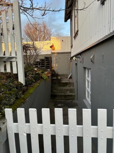 a white picket fence in front of a house at Apartment in Reykjavikurvegur - Birta Rentals in Hafnarfjördur