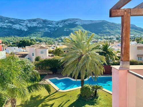 a villa with a swimming pool and palm trees at Hoteltype Penthouse 2 Beds, Parking, WIFI & pool Stunning Views in Denia