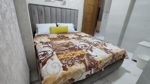 een bed met een deken en een geel kussen erop bij Ibraimo in Fès