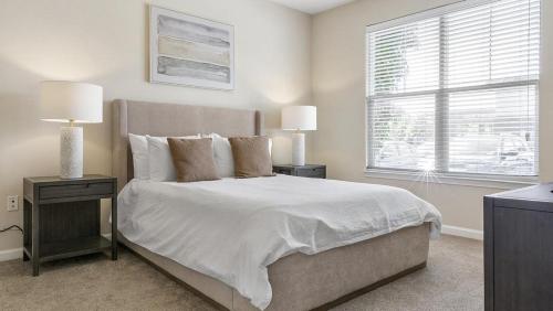 um quarto com uma cama com duas mesas de cabeceira e uma janela em Landing - Modern Apartment with Amazing Amenities (ID1196X495) em Fishers