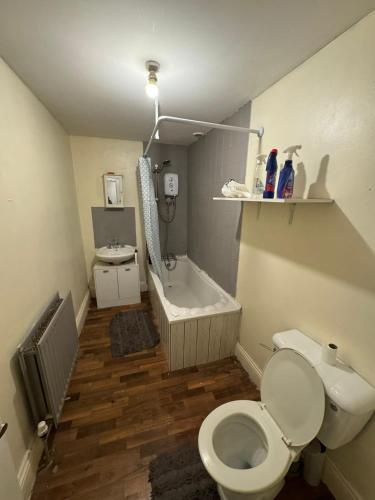 a bathroom with a toilet and a bath tub at Huddersfield house in Huddersfield