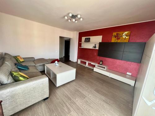 ein Wohnzimmer mit einem Sofa und einem Flachbild-TV in der Unterkunft Amy's Bright Apartment in Constanţa