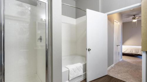 uma casa de banho com um chuveiro e uma porta de vidro em Landing - Modern Apartment with Amazing Amenities (ID5045X9) em San Antonio