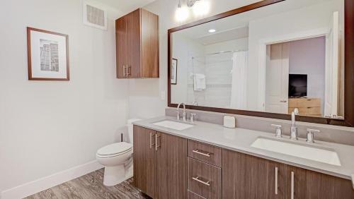 uma casa de banho com um WC, um lavatório e um espelho. em Landing - Modern Apartment with Amazing Amenities (ID5411) em Fort Worth