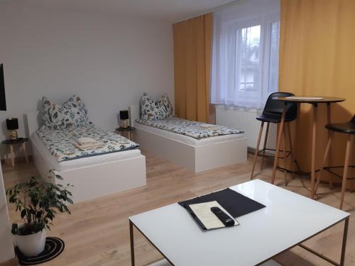 ein Wohnzimmer mit 2 Betten und einem Tisch in der Unterkunft Vilka Čachtice in Čachtice