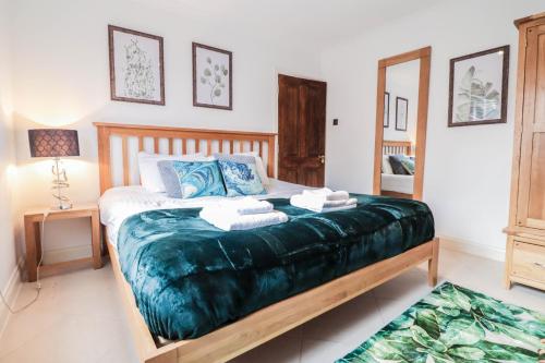 a bedroom with a bed with towels on it at Luxurious 5 Bed Property! in Woodley