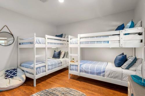 two white bunk beds in a room with wood floors at Family Lakefront Retreat in Granite Shoals