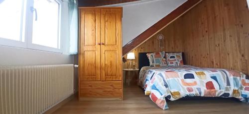 ein Schlafzimmer mit einem Bett und einer Holztreppe in der Unterkunft Appartement T2 au 1er étage in Margny-lès-Compiègne