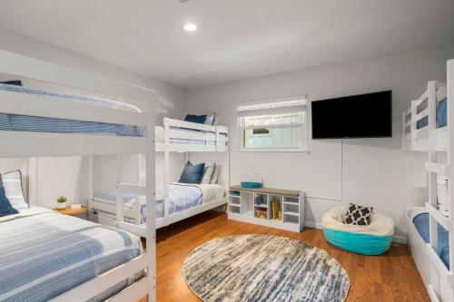 a bedroom with two bunk beds and a flat screen tv at Family Lakefront Retreat in Granite Shoals