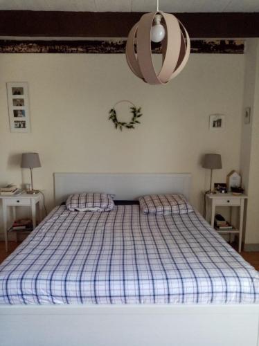 - une chambre dotée d'un lit avec une couverture bleue dans l'établissement Kerfly, à Plouër-sur-Rance