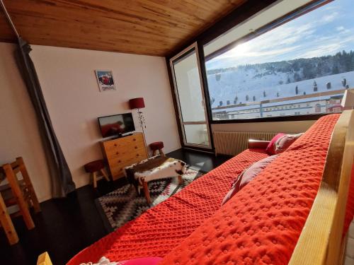 a bedroom with a bed and a large window at Résidence LES CHAMOIS Pied des pistes Chamrousse in Chamrousse