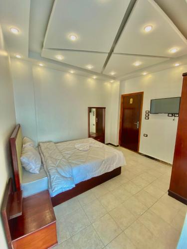 a bedroom with a bed and a tv in it at Enjoy Giza Pyramids View in Cairo