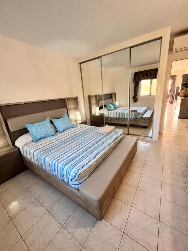 a bedroom with a bed with blue pillows and a mirror at Acogedor Apartamento Con Vistas in Callao Salvaje