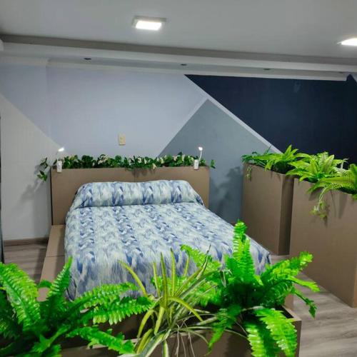 a bedroom with a bed with plants in it at Stylish studio apartment in Quito