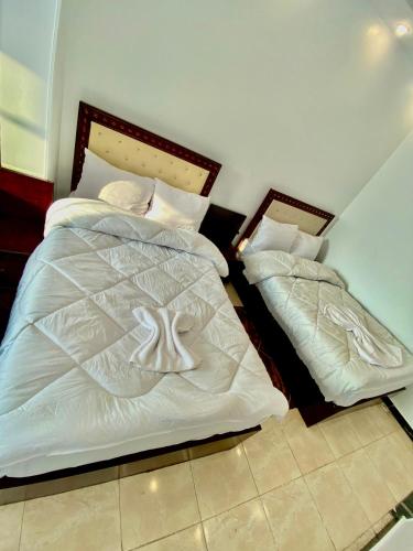two beds sitting next to each other in a bedroom at Enjoy Giza Pyramids View in Cairo