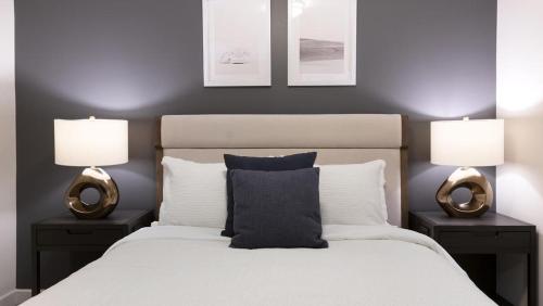 een slaapkamer met 2 nachtkastjes en een bed met 2 lampen bij Landing - Modern Apartment with Amazing Amenities (ID8555X85) in Lewinsville