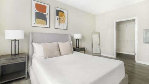 um quarto branco com uma cama grande e 2 candeeiros em Landing - Modern Apartment with Amazing Amenities (ID1375X557) em Wake Forest