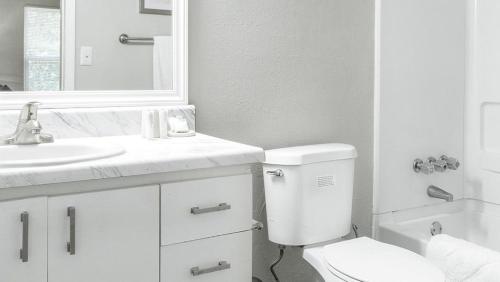 ein weißes Bad mit einem WC und einem Waschbecken in der Unterkunft Landing - Modern Apartment with Amazing Amenities (ID9232X12) in Forest Park