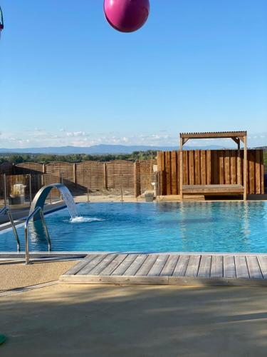 a large swimming pool with a red ball in the air at Camping Les Amandiers in Castelnau-de-Guers