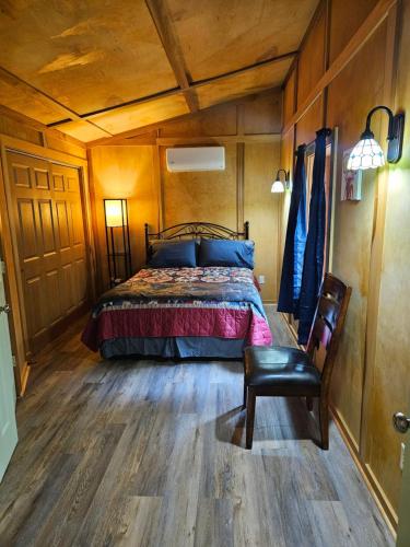 a bedroom with a bed and a chair in a room at Frog Hollow at Hocking Vacations in Logan