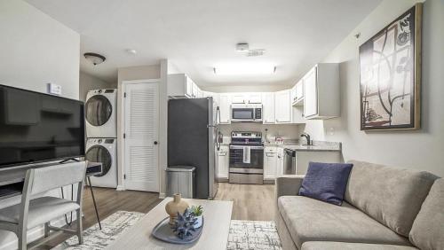 een woonkamer met een bank en een keuken bij Landing - Modern Apartment with Amazing Amenities (ID1292X514) in Lexington