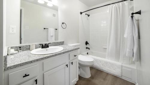 een witte badkamer met een wastafel en een toilet bij Landing - Modern Apartment with Amazing Amenities (ID1292X514) in Lexington