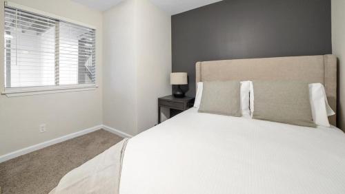 een slaapkamer met een groot wit bed en een raam bij Landing - Modern Apartment with Amazing Amenities (ID1292X514) in Lexington