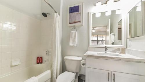 biała łazienka z toaletą i umywalką w obiekcie Landing - Modern Apartment with Amazing Amenities (ID7593X55) w Orlando