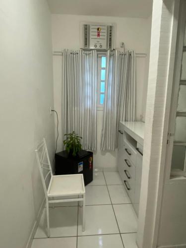 a white room with a chair and a window at Caminho das Pedras Búzios in Búzios