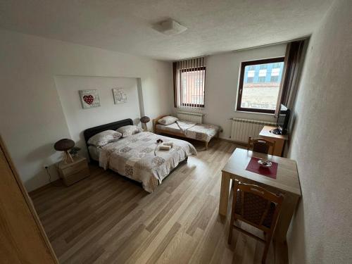 Un dormitorio con una cama y una mesa. en stari grad, en Doboj