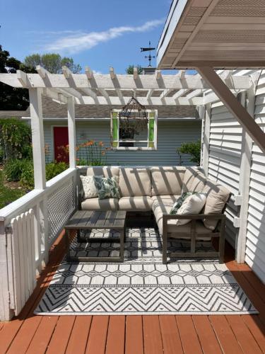 a patio with a couch on a deck at Cozy Algoma Retreat! Minutes to Beach and Downtown! in Algoma