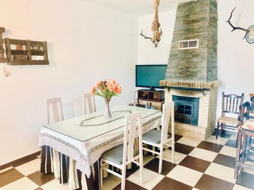 uma sala de jantar com uma mesa e uma lareira em LOS ROSALES em Alcaracejos