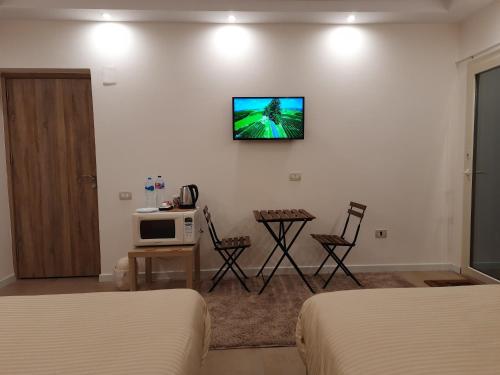 a hotel room with two beds and a tv on the wall at Fantastic new rooms close to New Cairo Festival City and airport in Cairo