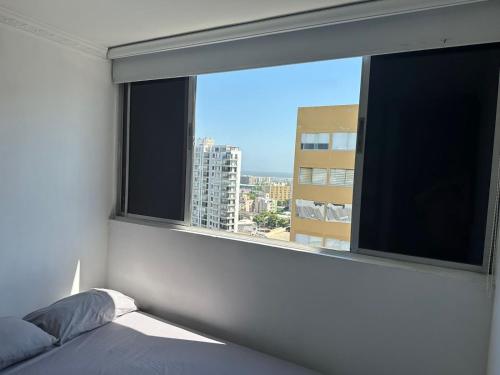 1 dormitorio con ventana y vistas a la ciudad en Apartamento, en las mejores zonas de Barranquilla, en Barranquilla