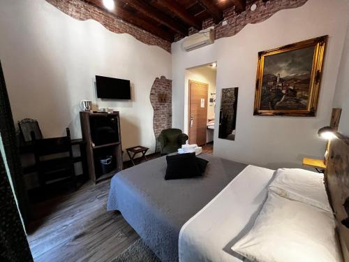 a hotel room with a bed and a chair at La Taverna del Metallo Rooms in La Spezia