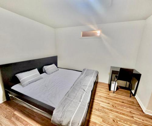 ein Schlafzimmer mit einem großen Bett mit weißer Bettwäsche in der Unterkunft Cozy 2BR Basement Apt in Newmarket in Newmarket