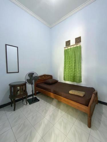 um quarto com uma cama e uma cortina verde em Malaya em Ngabean