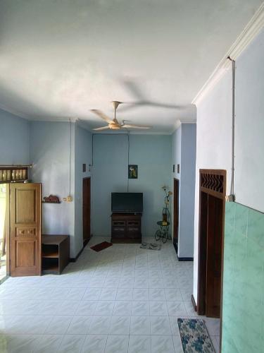 uma sala de estar vazia com uma ventoinha de tecto em Malaya em Ngabean