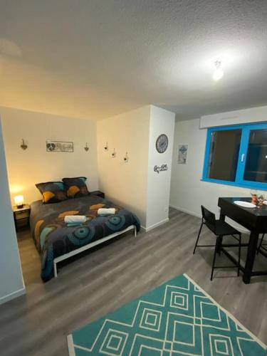 une chambre avec un lit, une table et un bureau dans l'établissement Strasbourg Lifestyle, à Strasbourg
