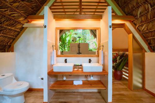 a bathroom with two sinks and a toilet at Shawandha Lodge in Puerto Viejo