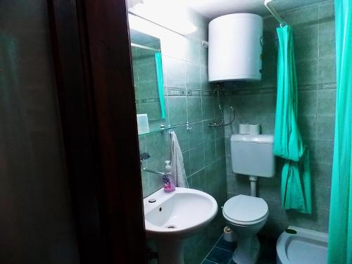 a bathroom with a white sink and a toilet at Zura Apartments in Ohrid